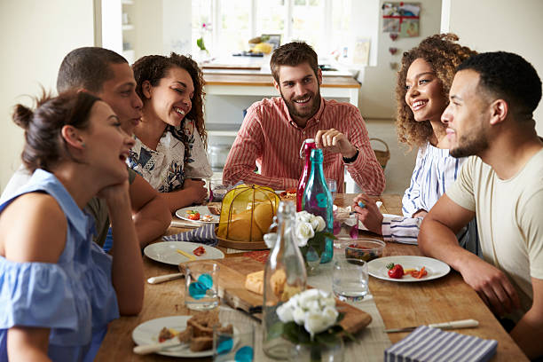 Young adults laughing as they talk at a table over lunch