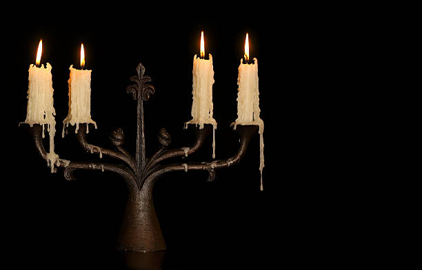istock burning old candle vintage bronze candlestick. Isolated Black Background. 626224126