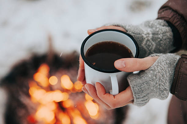 istock Cup of coffee in hands and fire 626224854