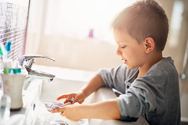 istock Little boy playing with paper boat in sink 626230514