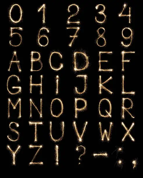Photo of English Letters from sparklers, alphabet and numbers on black background.