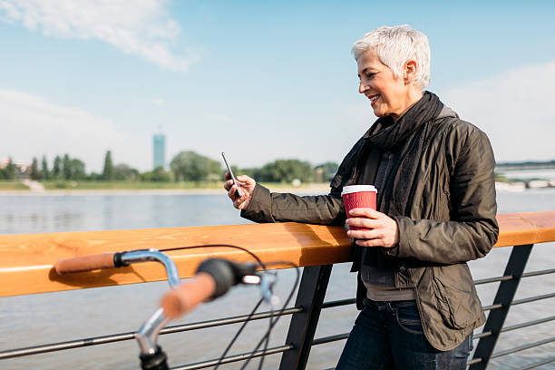 istock Mature Woman Standing On The Rivereside And Drinking Coffee. 626231572