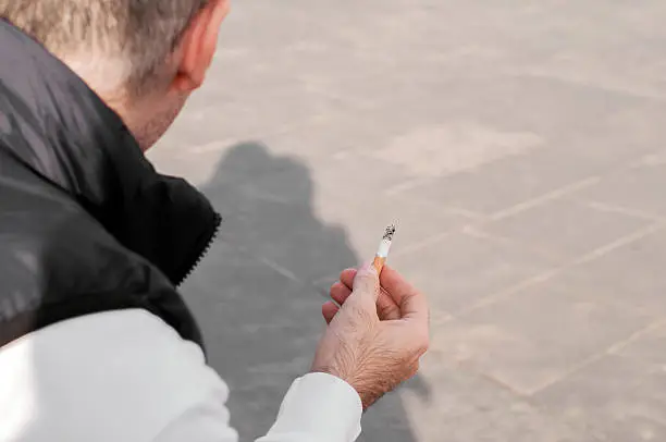 Photo of Man smoke the Cigarette on the Street. man smoking outside