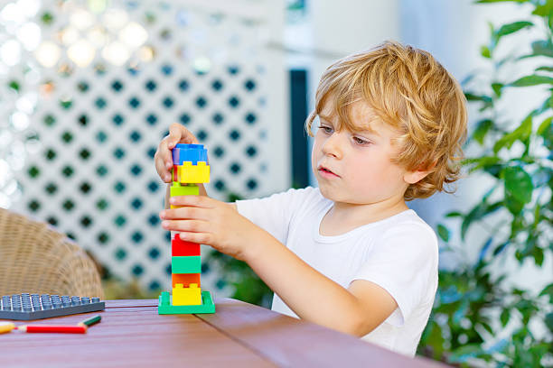 istock Little kid boy playing with colorful plastic blocks 626233484