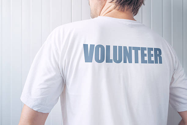 istock Guy wearing shirt with Volunteer label printed on back 626234304