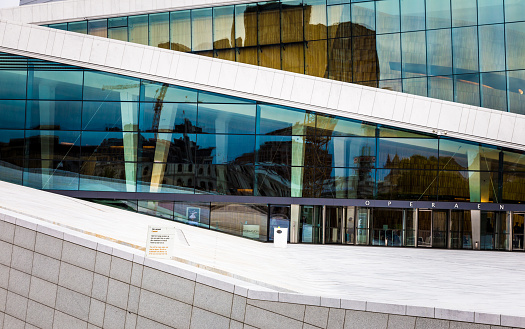 Oslo, Norway - June 13, 2015: close up image of the angular lines and reflective windows of the modern architecture of Oslo Opera House, in Oslo, the capital city of Norway. The Oslo Opera House is the home of The Norwegian National Opera and Ballet, and the national opera theatre in Norway. The building is situated in the Bjørvika neighborhood of central Oslo, at the head of the Oslofjord.