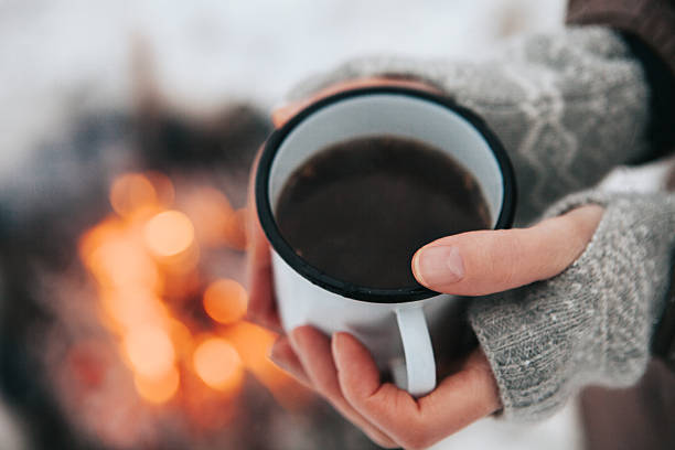 istock Cup of coffee in hands and fire 626235470