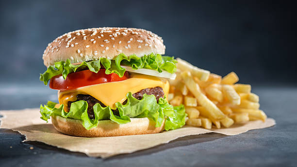 Fresh burger and fries on baking paper stock photo