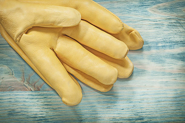 istock Leather protective gloves on wood board construction concept 626243318