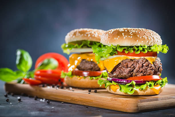 istock Two Home Made Huge Cheeseburger on oak chopping board 626243566