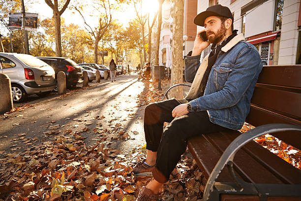 istock Hipster on a bench with smartphone 626247830
