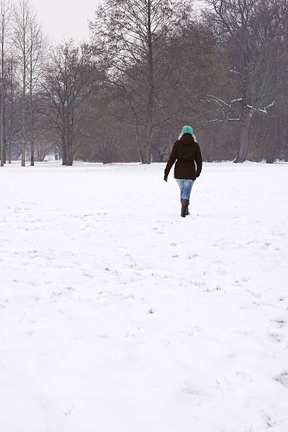 istock woman walking across snow covered field 626253440