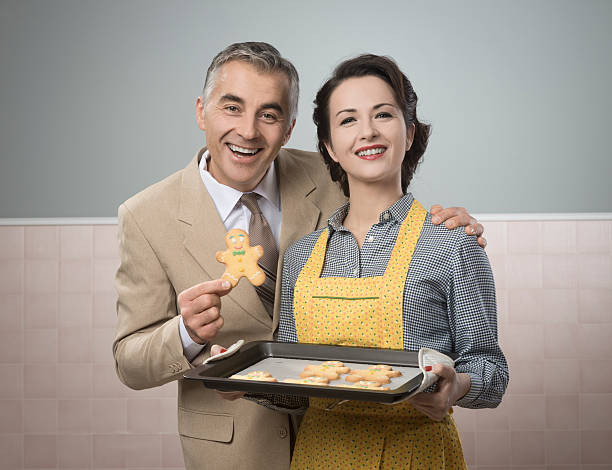 Vintage woman serving home made gingerbread men cookies to her smiling husband