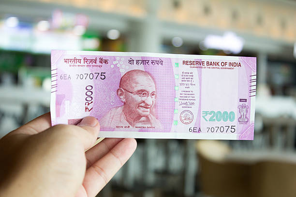 istock Man hold 2000 rupee banknote on mall background 626257460