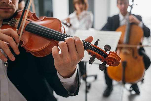 istock Violinist performing on stage with orchestra 626259216