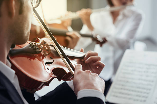 istock Violinist performing on stage with orchestra 626260324