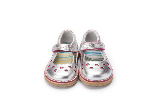 Pair of girls toddler or childs silver leather pretty shoe shot at a 3/4 angle on a white background