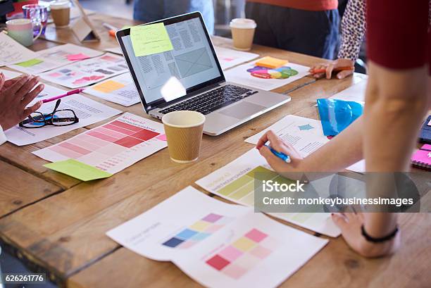 Close Up Of Designers Discussing Layouts And Color Schemes Stock Photo - Download Image Now