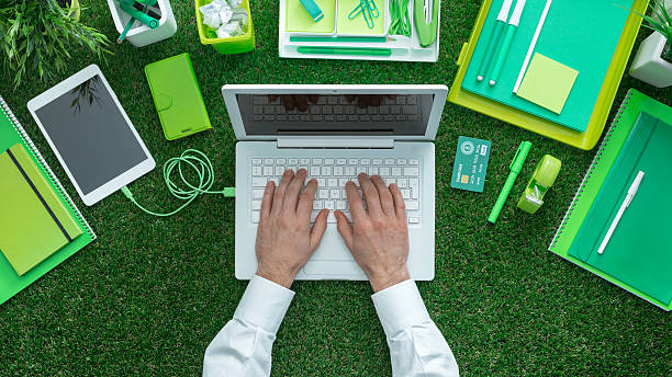 Green business concept Businessman using a laptop and networking on the grass; green business, sustainability and communication concept sustainable business stock pictures, royalty-free photos & images