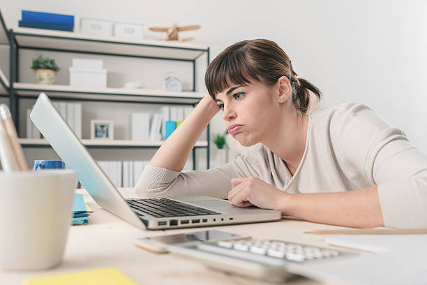 mulher desapontada trabalhando com um laptop - tédio - fotografias e filmes do acervo