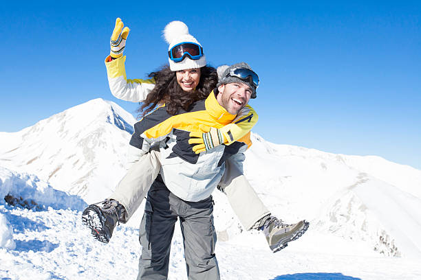 istock Friends having fun in piggyback ride on top snow mountain 626263962