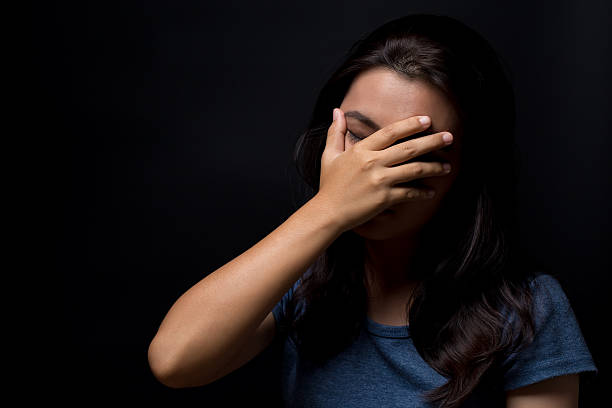 istock Sad woman on isolated black background 626264304