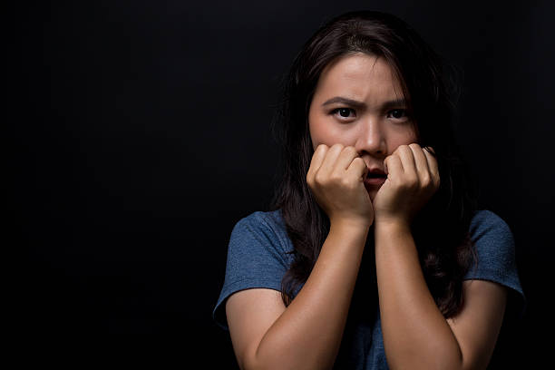 istock Scared woman on isolated black background 626264450