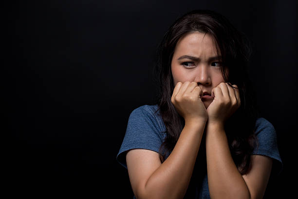 istock Scared woman on isolated black background 626264542