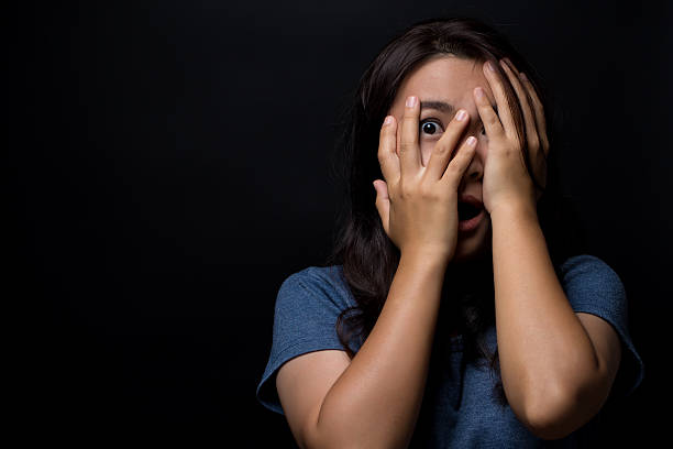 istock Scared woman on isolated black background 626264714