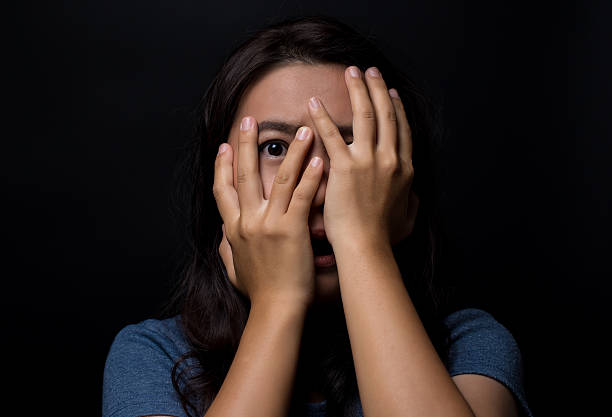 istock Scared woman on isolated black background 626264800