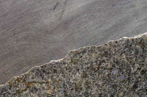 dark polished stone with an irregular fracture in the background ebony. Top view, space for text