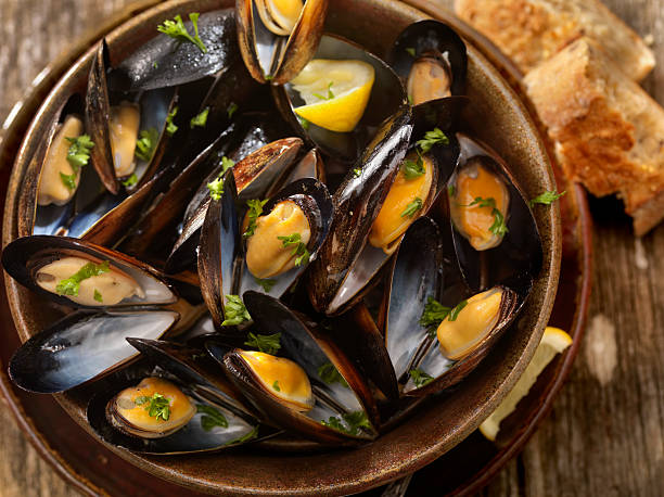 Steamed Mussels Steamed Mussels with Fresh Parsley, Bread and a Couple of Beers -Photographed on Hasselblad H3D2-39mb Camera Mussels stock pictures, royalty-free photos & images