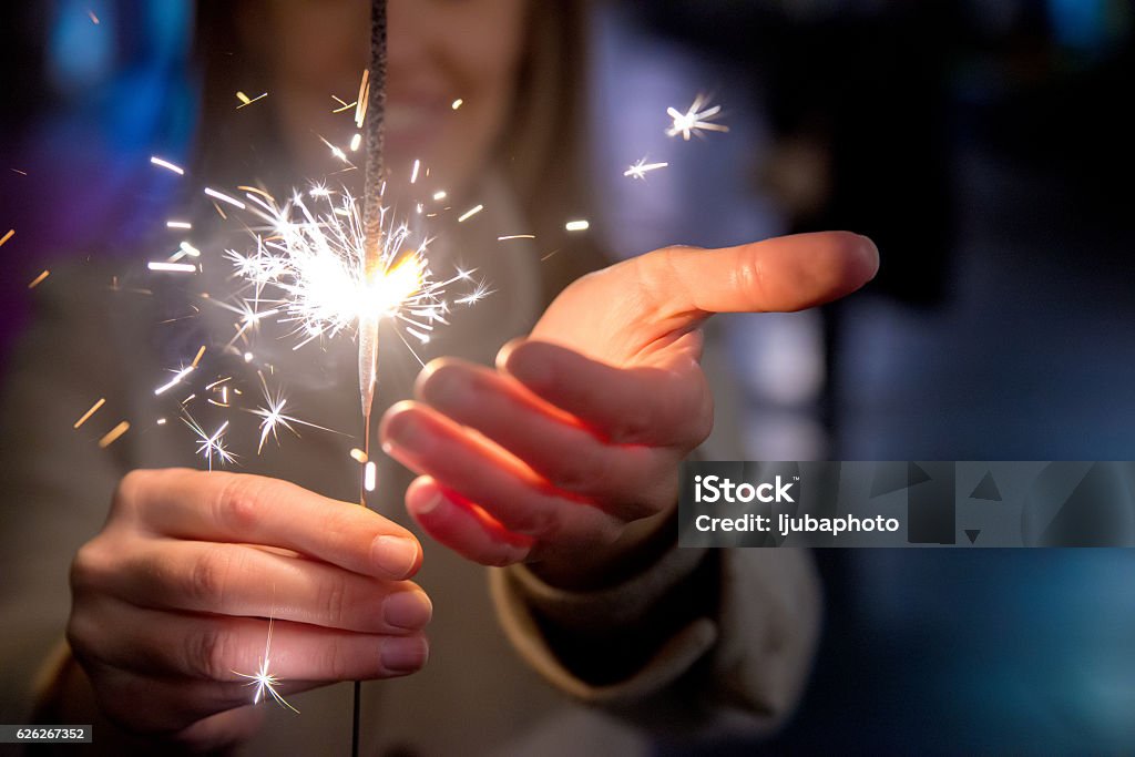 Happy New Year Woman celebrating christmas with bengal fire on the street by night Firework - Explosive Material Stock Photo