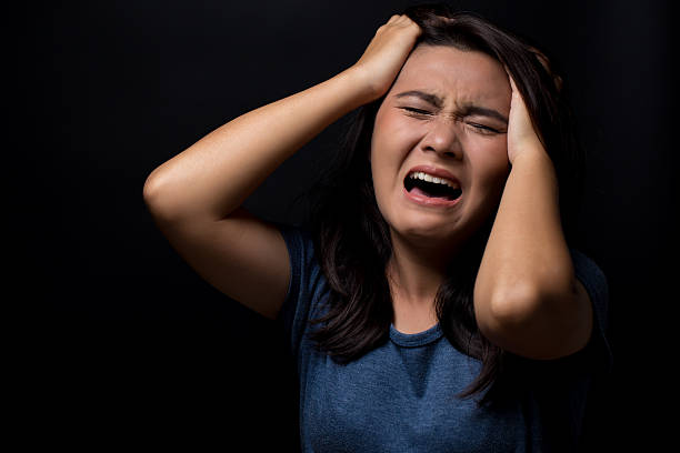 istock Screaming woman on black background 626267860