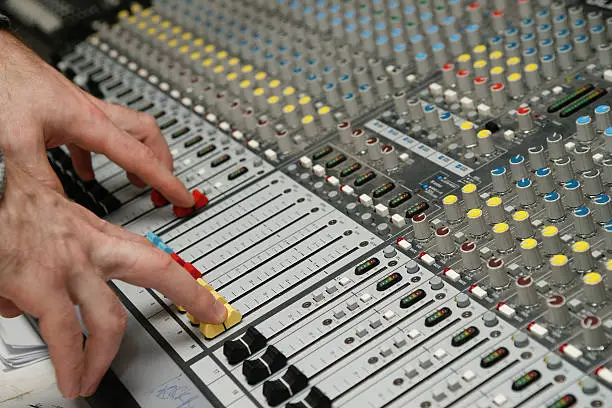 Photo of Sound engineer works with sound mixer