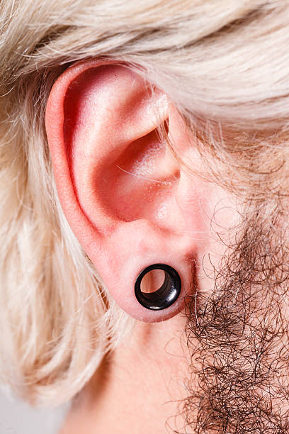 istock Pierced man ear, black plug tunnel 626289270