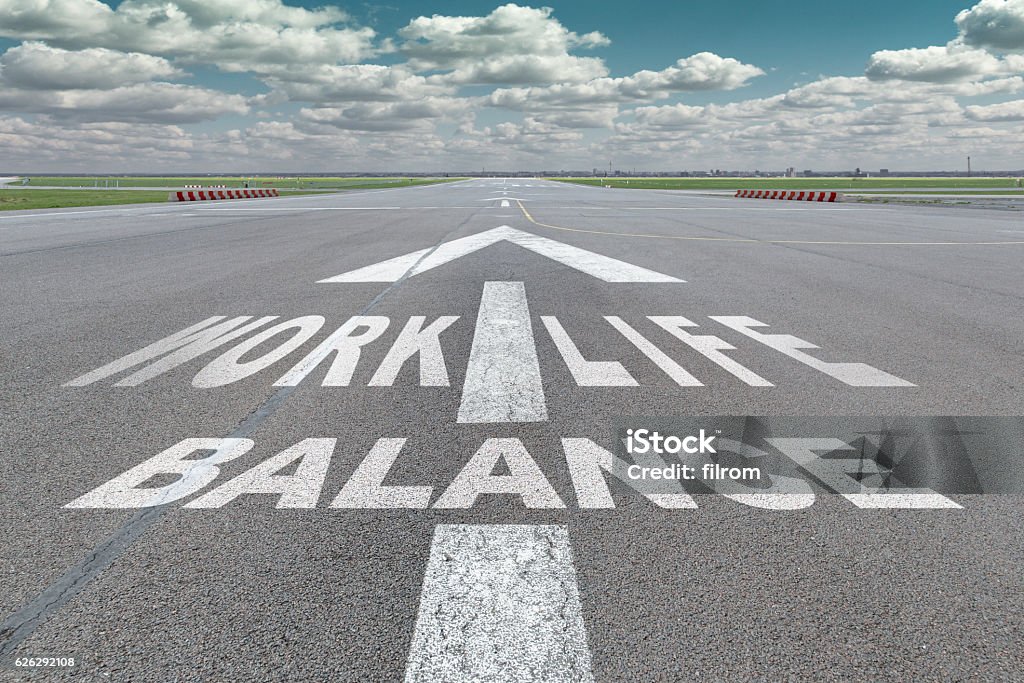 Airport runway arrow Runway of airport with arrow guideline and "work life balance" letters painted on the surface Life Balance Stock Photo