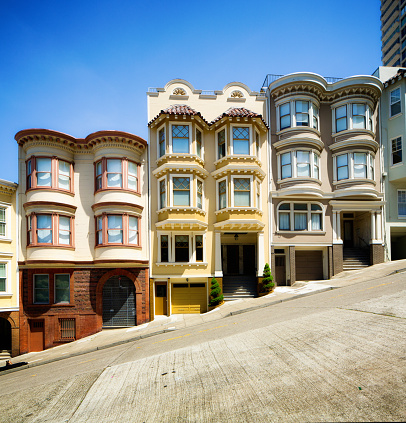 Row of colorful Italian style San Francisco townhouses built on steep hill.