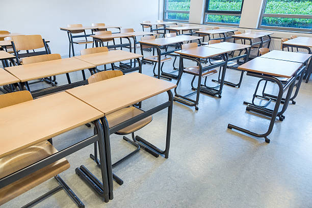 istock Rows of tables and chairs in classroom 626302446