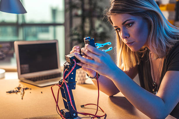 Robotics is her passion Young woman working in a robotics workshop. robotics photos stock pictures, royalty-free photos & images