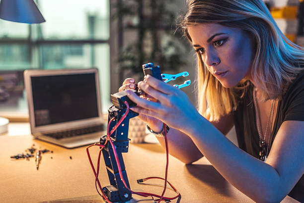 Robotics is her passion Young woman working in a robotics workshop. stem topic stock pictures, royalty-free photos & images