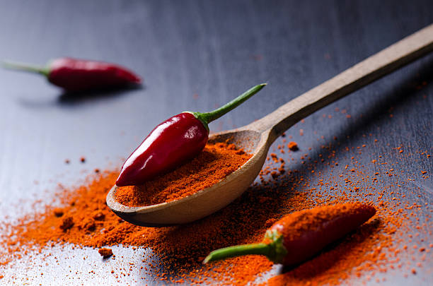 istock Red chilly peppers on a wooden, black table with spicy. 626324380