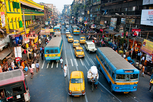 Kolkata, India - January 20, 2013: Lines of the yellow Ambassador taxi cabs and buses on the road of the city on January 20, 2013. Kolkata has a density of 814.80 vehicles per km road length