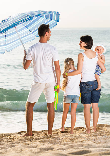 istock Glad family of four standing with back forward 626324930