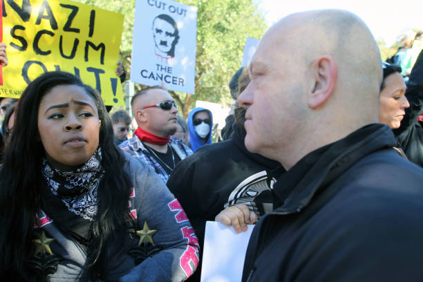 Austin, Texas, USA - November 19, 2016: A young African American woman counter-demonstrator and a 'White Lives Matter' supporter stare at each other across the metal fence marking the southern boundary of the Capitol grounds. The 'White Lives Matter' demonstrators, numbering about 20 people at the most, came from Houston with the message that the hate crime law is unfair to white people.