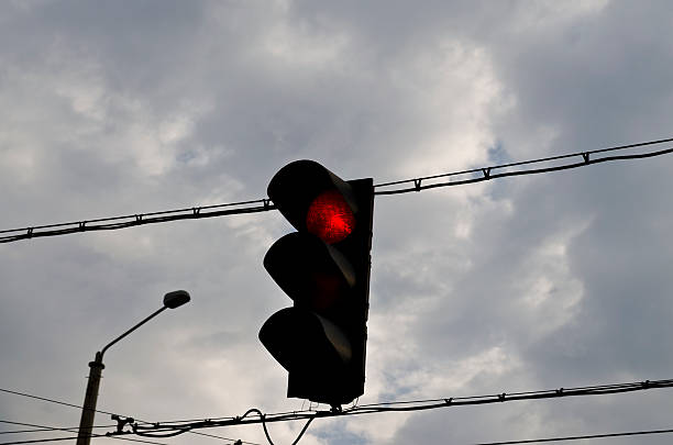istock Traffic light with red light against the morning sky 626332258