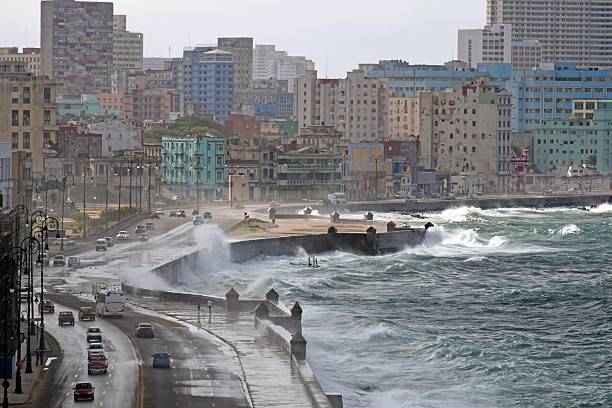 fuerte y violento olas recorrer la costa en la ciudad - hurricane lantern fotografías e imágenes de stock