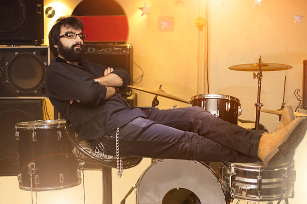 istock Drummer relaxed sitting at drum kit before concert. 626339718