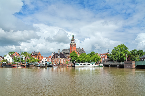 Leer, Germany. View from Leda river on City Hall in Dutch Renaissance style, Old Weigh House in Dutch classical Baroque style, Tourist Harbor and Bridge of Erich vom Bruch.