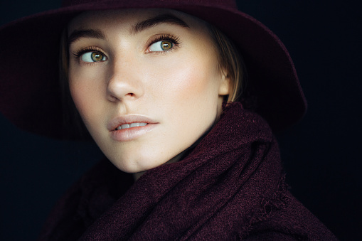 Beautiful girl with make-up wearing red hat and scarf